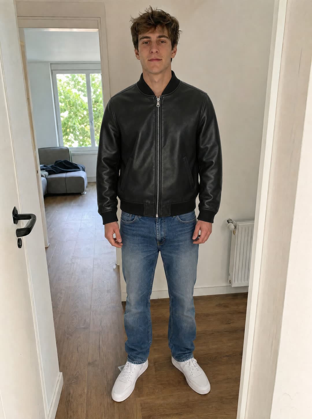 The same person in a black leather bomber jacket