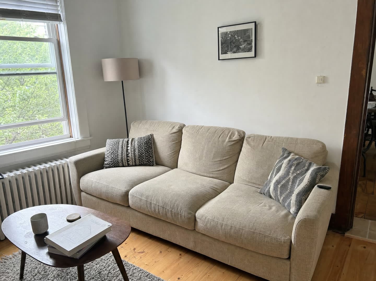 A living room with a beige fabric sofa